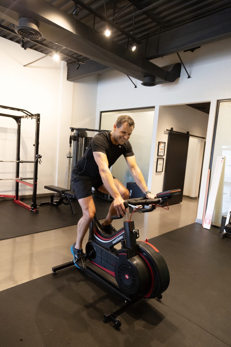 A man on a bycicle machine in a gym