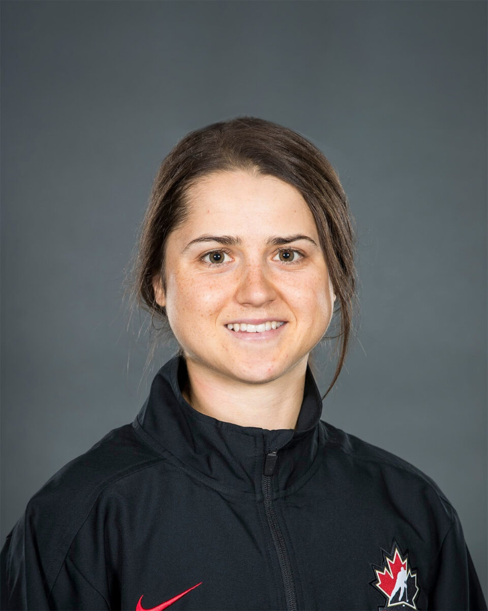 A woman in a black jacket is posing for a photo.