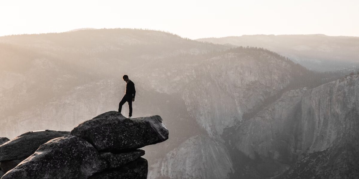 A man standing on top of a rock in yosemite national park.