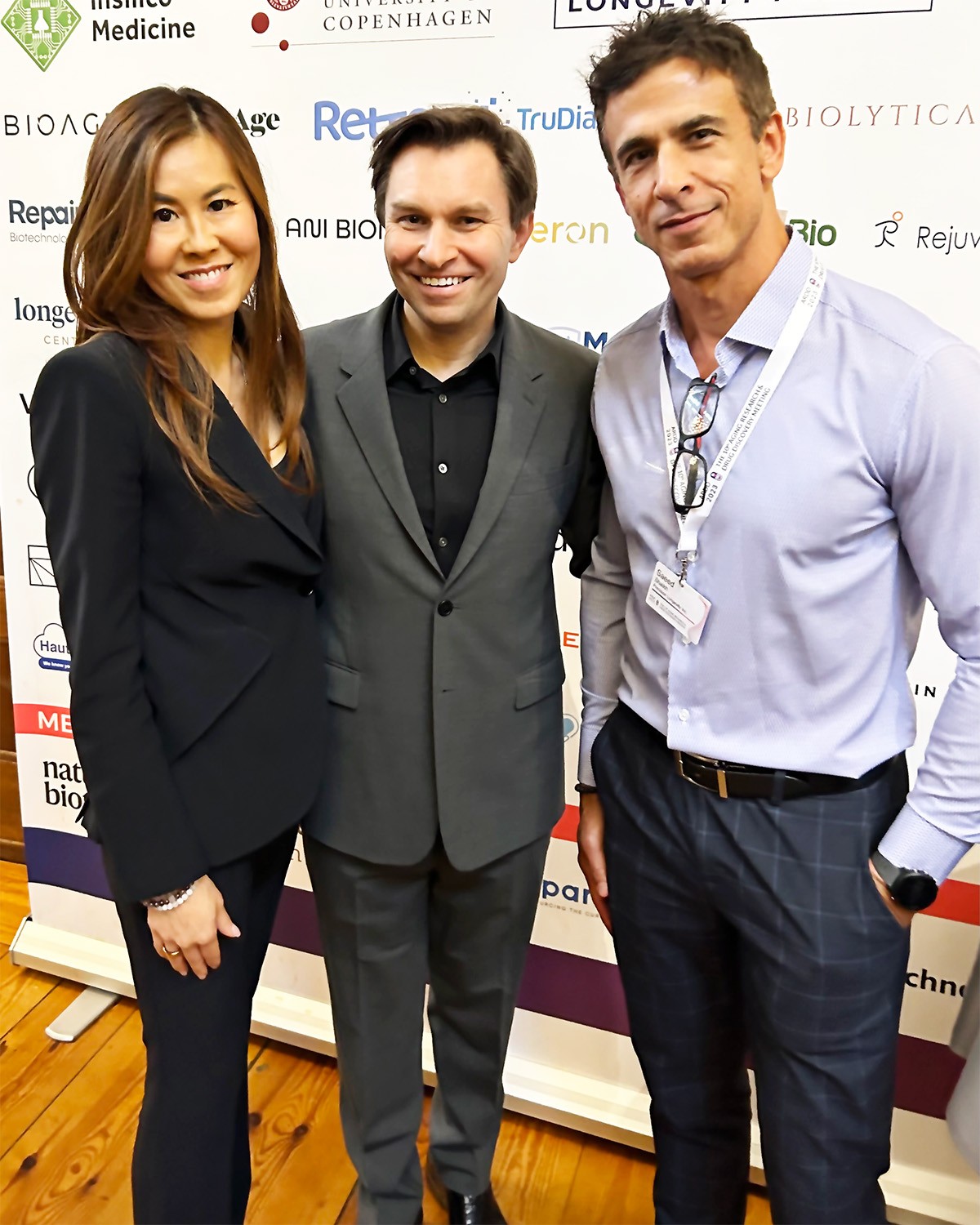 Two men and a woman posing with precision for a photo at a long-lasting event.